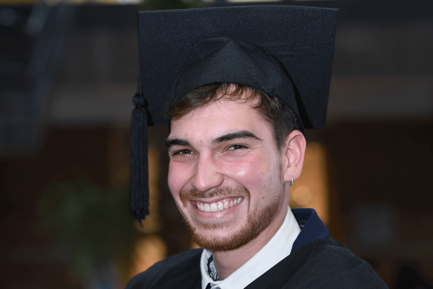 A man in a graduations cap and gown. 