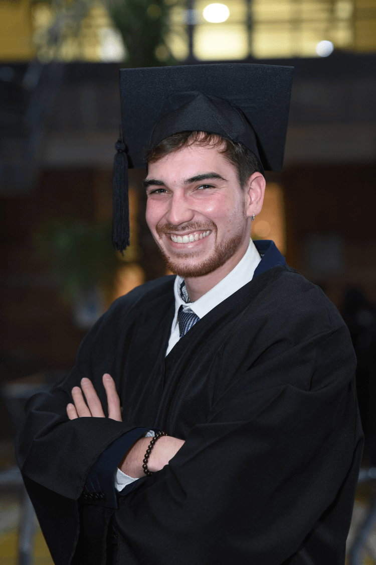 A man in a graduations cap and gown. 