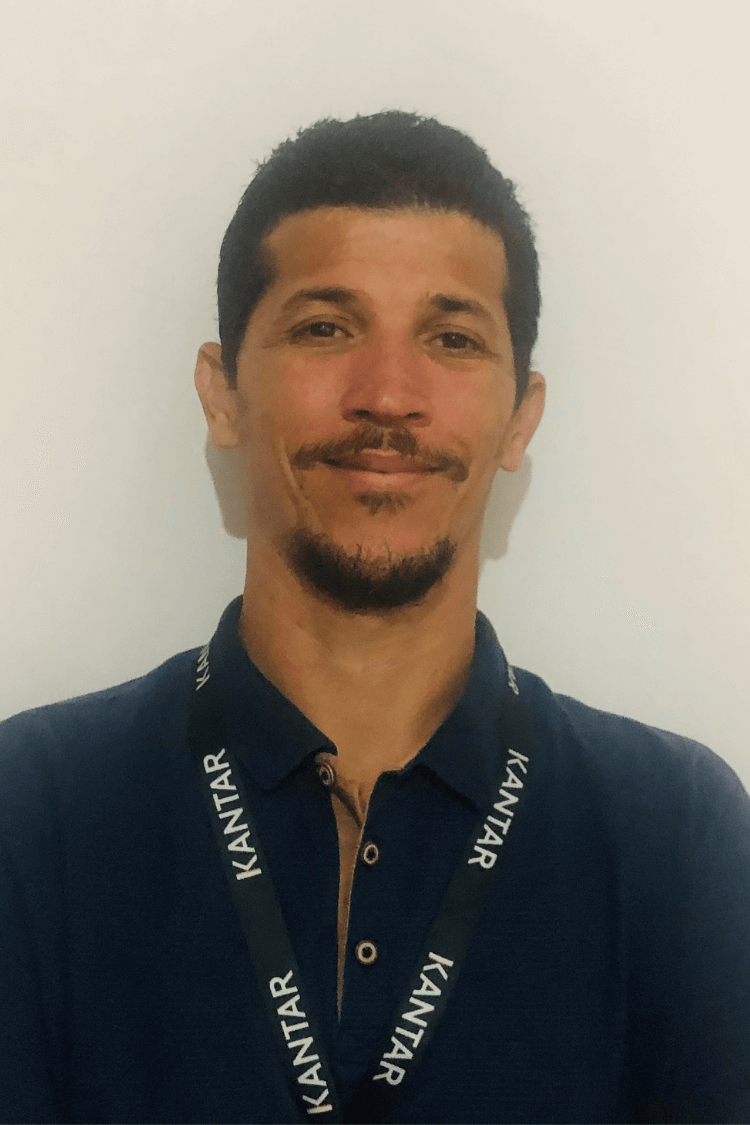 A man dark hair and a dark brown beard. He is wearing a navy shirt and you can also see his Kantar lanyard.
