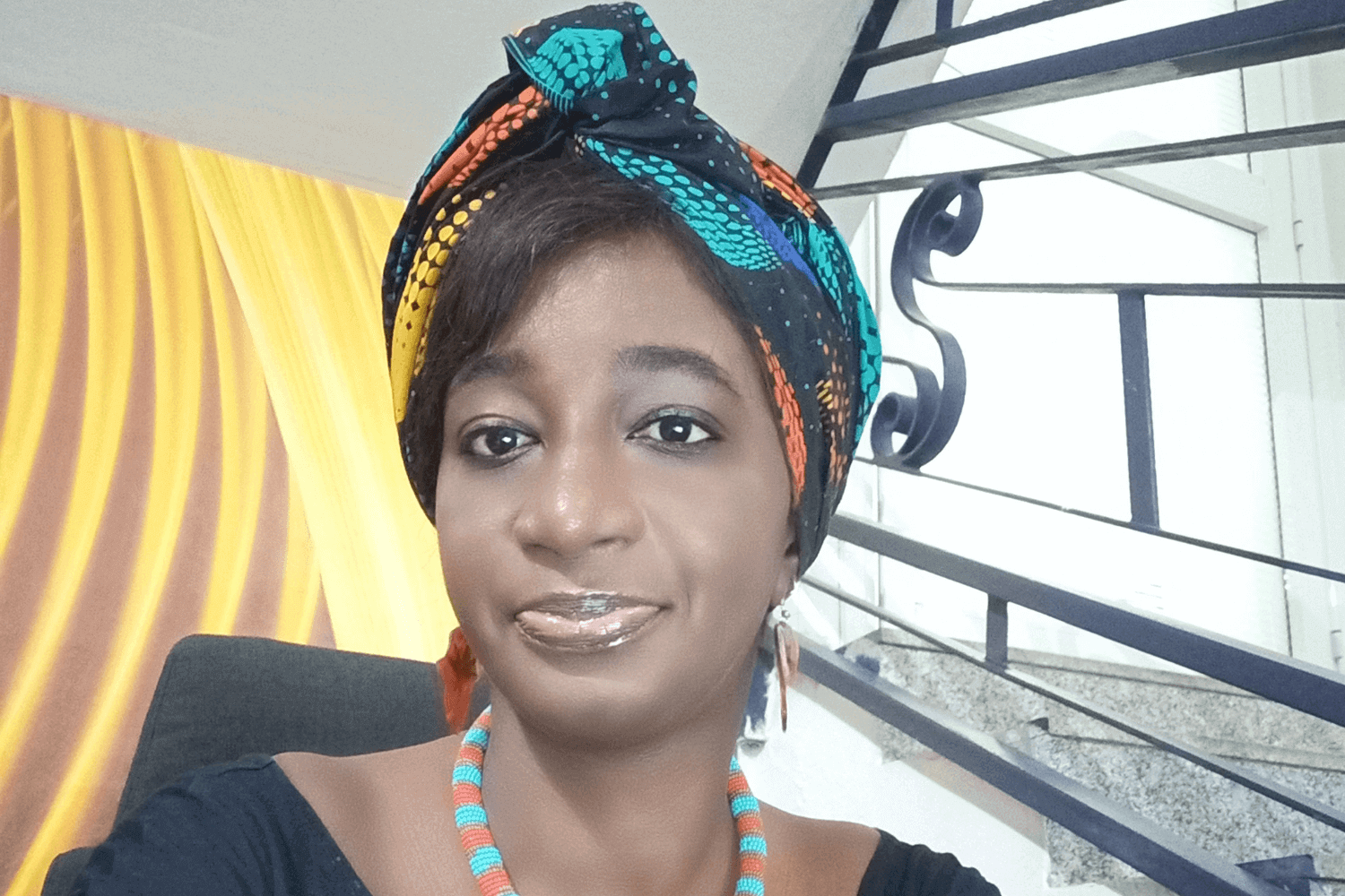 Une femme avec un haut bleu et un foulard multicolore. 