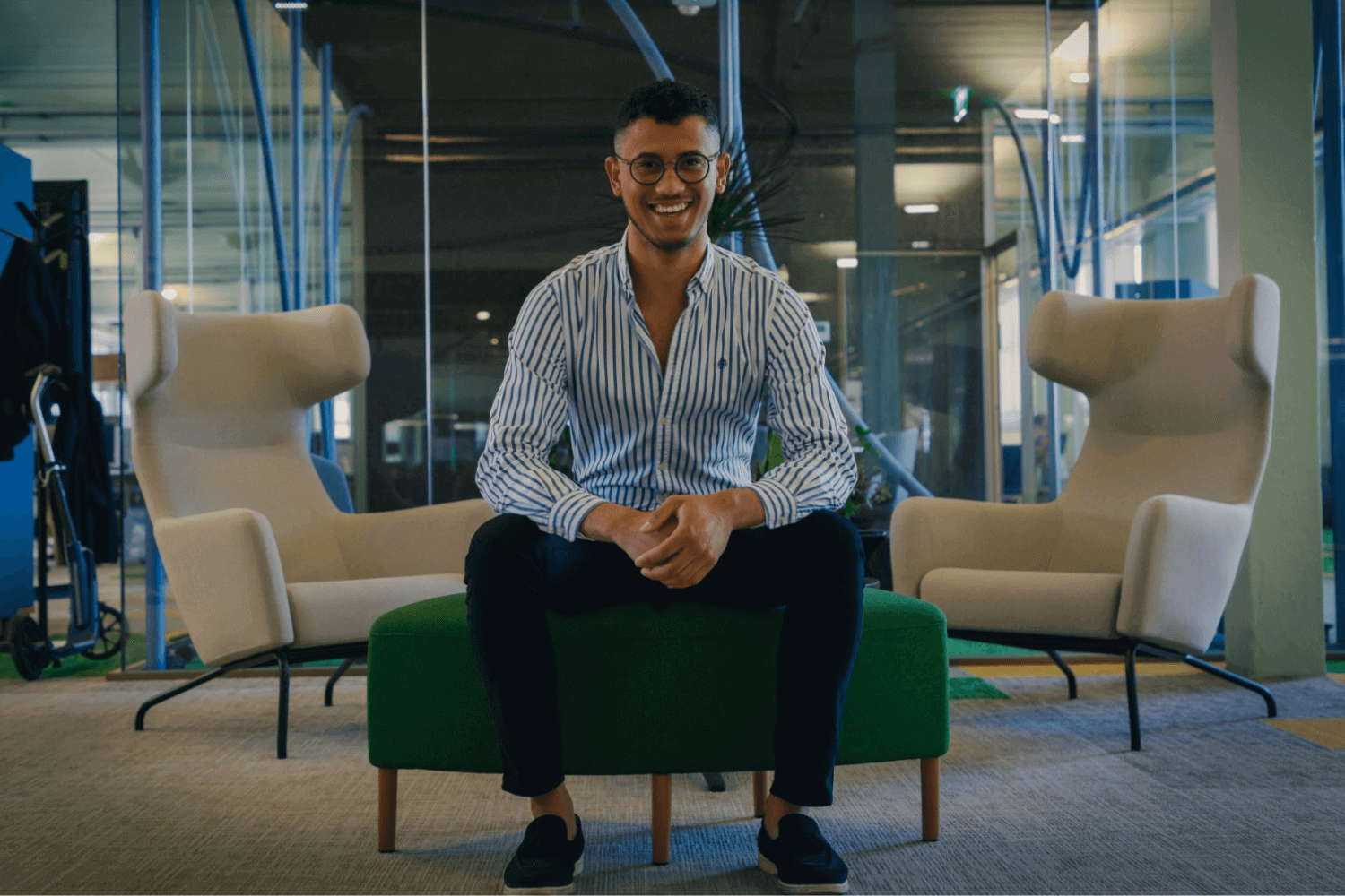 Un homme assis sur un banc porte une chemise bleue. 