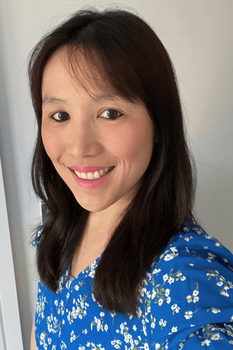 一名棕色长发及肩的女性，身穿蓝白相间的花朵图案衬衫。